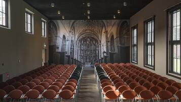 A church interior with rows of chairs facing an altar, large windows, and a high ceiling.