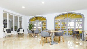 Un comedor moderno con paredes blancas, ventanas amplias y piso pulido.