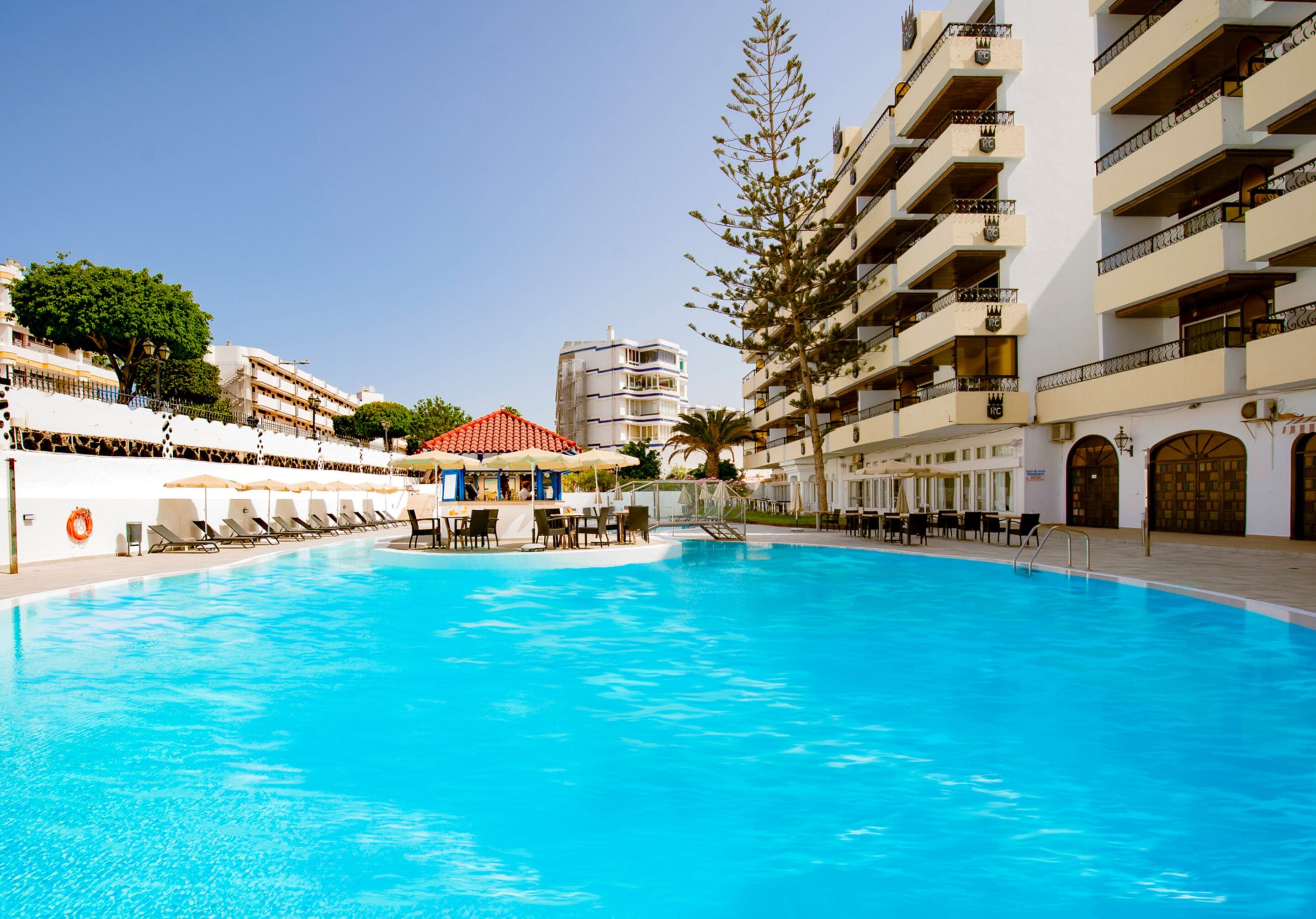 Una piscina al aire libre, tumbonas