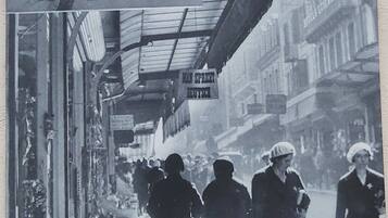 A vintage street scene with a sign advertising 'Berceau Authentique Soubibrous' and 'Entree Libre'.