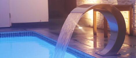 Una piscina interior moderna con una fuente de agua.