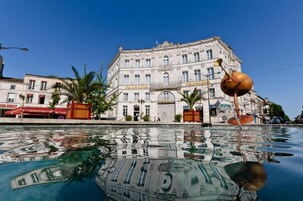 Un edificio histórico con la señalización "FRANCOIS" y "PREMISES", reflejado en una masa de agua.