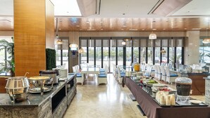 Ein reichhaltiges Buffet mit mehreren Servierstationen, einer langen Theke und einem Sitzbereich mit Tischen und Stühlen.