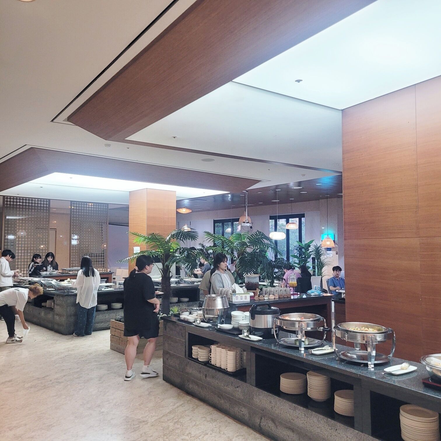 Ein Buffetbereich mit mehreren Servicestationen, einer Auswahl an Speisen und einem modernen Ambiente.