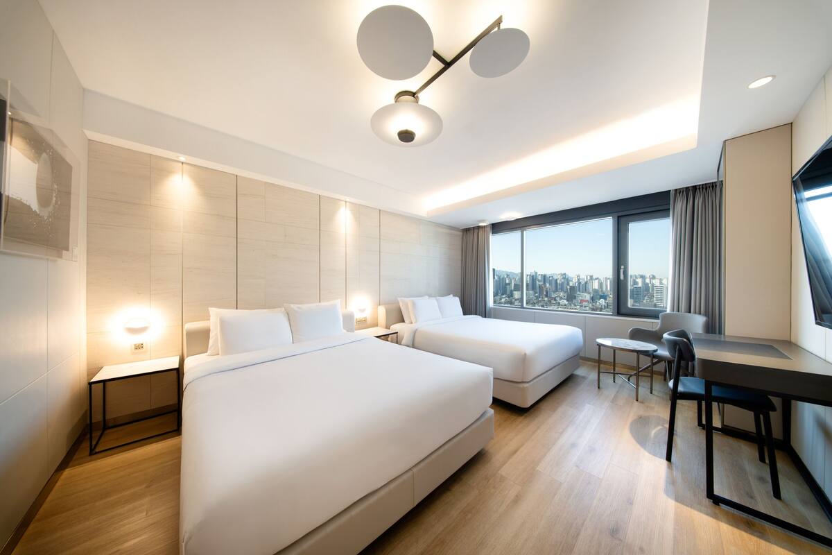 Una habitación de hotel moderna con dos camas, un escritorio y una silla.