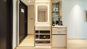 Un baño moderno con tocador, espejo y estantes para artículos de aseo.