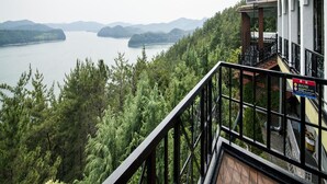 A balcony with a view of a lake surrounded by trees. - Asia Lakeside Hotel (Jinju)