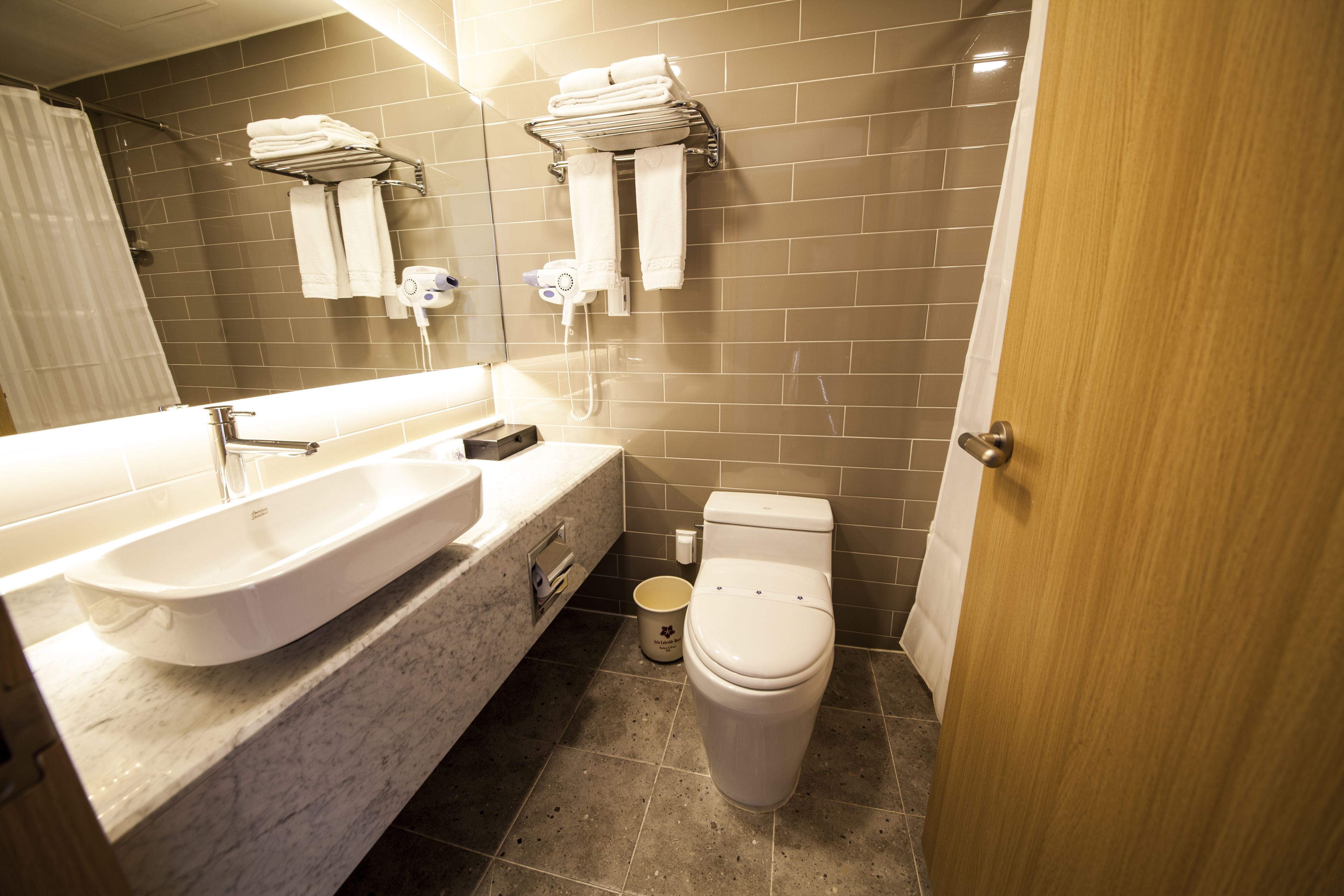 Un baño moderno con un lavamanos grande, un inodoro y una zona de ducha.