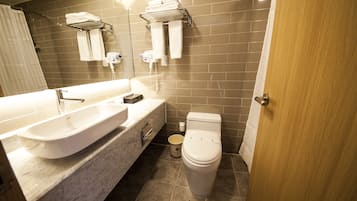 Un baño moderno con un lavamanos grande, un inodoro y una zona de ducha.
