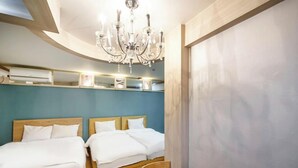 A hotel room with two beds, a chandelier, and a wooden ceiling.