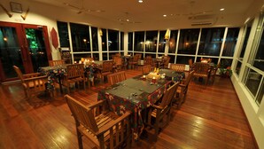Un comedor espacioso con suelo de madera y ventanas amplias.