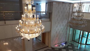 A spacious lobby with a large, ornate chandelier, a patterned floor, and a modern staircase. - Hotel Geumosan (Gumi)