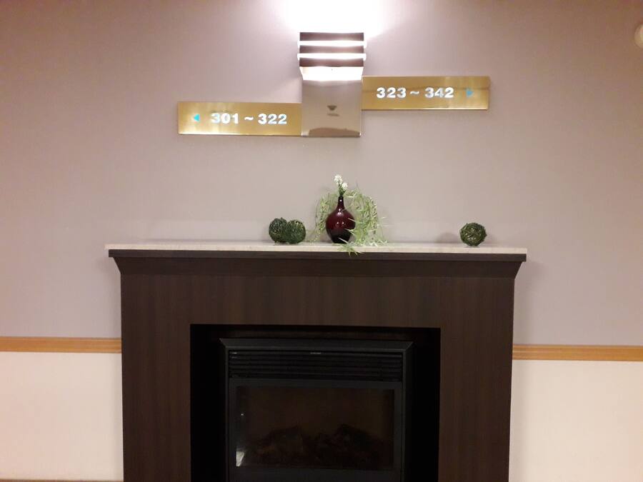 A fireplace with a mantel displaying room numbers 301-322 and 323-342.