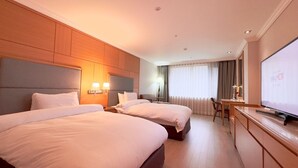 A hotel room with two beds, a desk, a TV, and a large window with curtains. - Hotel Geumosan (Gumi)