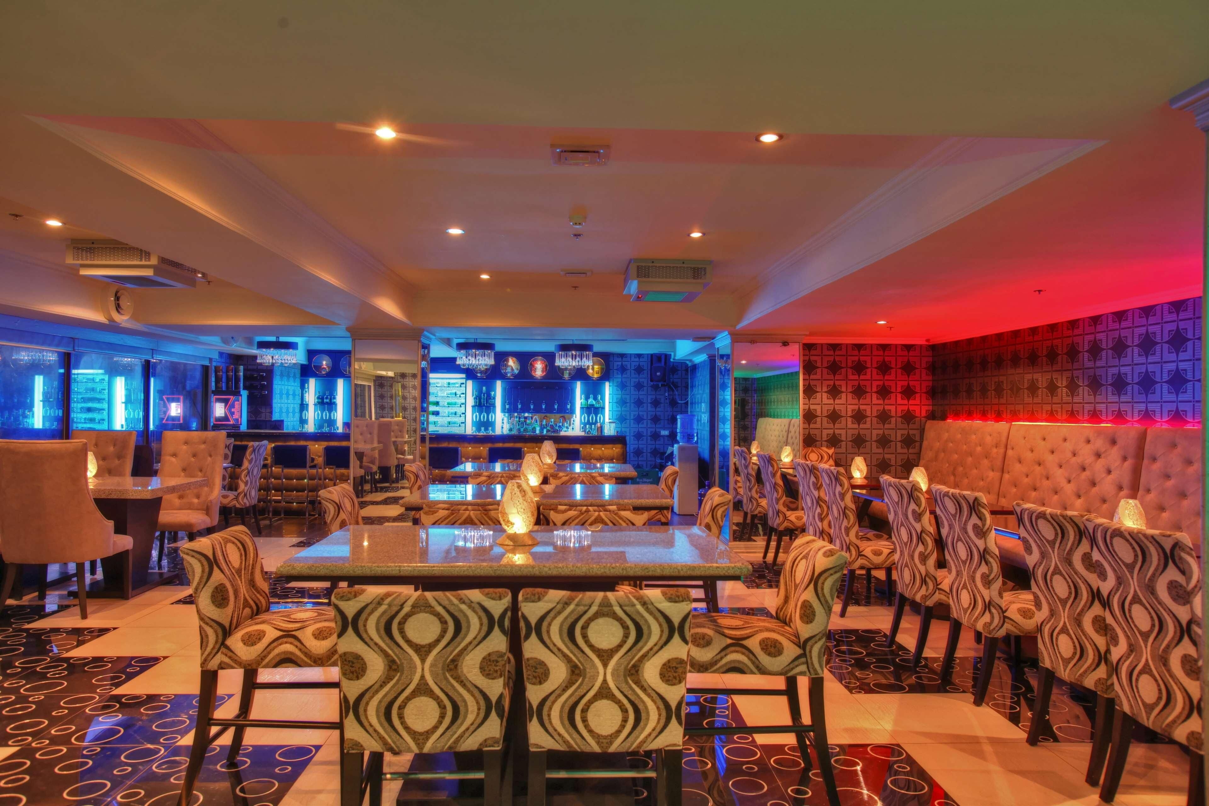 Un restaurant doté d’un bar, de chaises à motifs et d’un comptoir.