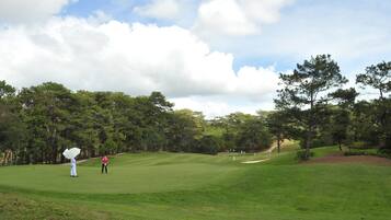 Enjoy a round of golf amidst lush greenery and dense trees.