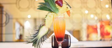 A cocktail with a pineapple garnish on a bar counter.