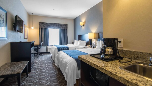 A hotel room with two beds, a desk, a chair, a coffee maker, and a sink. - Comfort Inn & Suites (Fort Saskatchewan)