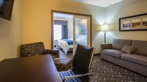 A hotel room with a bed, a sofa, a table, and a chair. - Comfort Inn & Suites (Fort Saskatchewan)