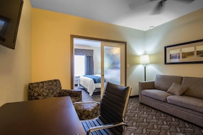 Una habitación de hotel con una cama, un sofá, una mesa y una silla.