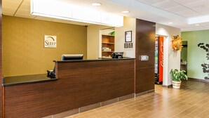 A reception desk with a sign for 'Sleep Inns & Suites', a Dell computer, and a Coca-Cola refrigerator. - Sleep Inn & Suites Mount Olive North (Mount Olive)
