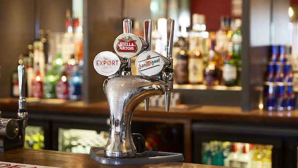 Un bar con varias griferías, incluyendo marcas como Stella Artois y San Miguel.