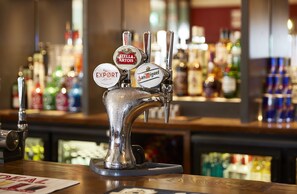 Un bar con varias griferías, incluyendo marcas como Stella Artois y San Miguel.