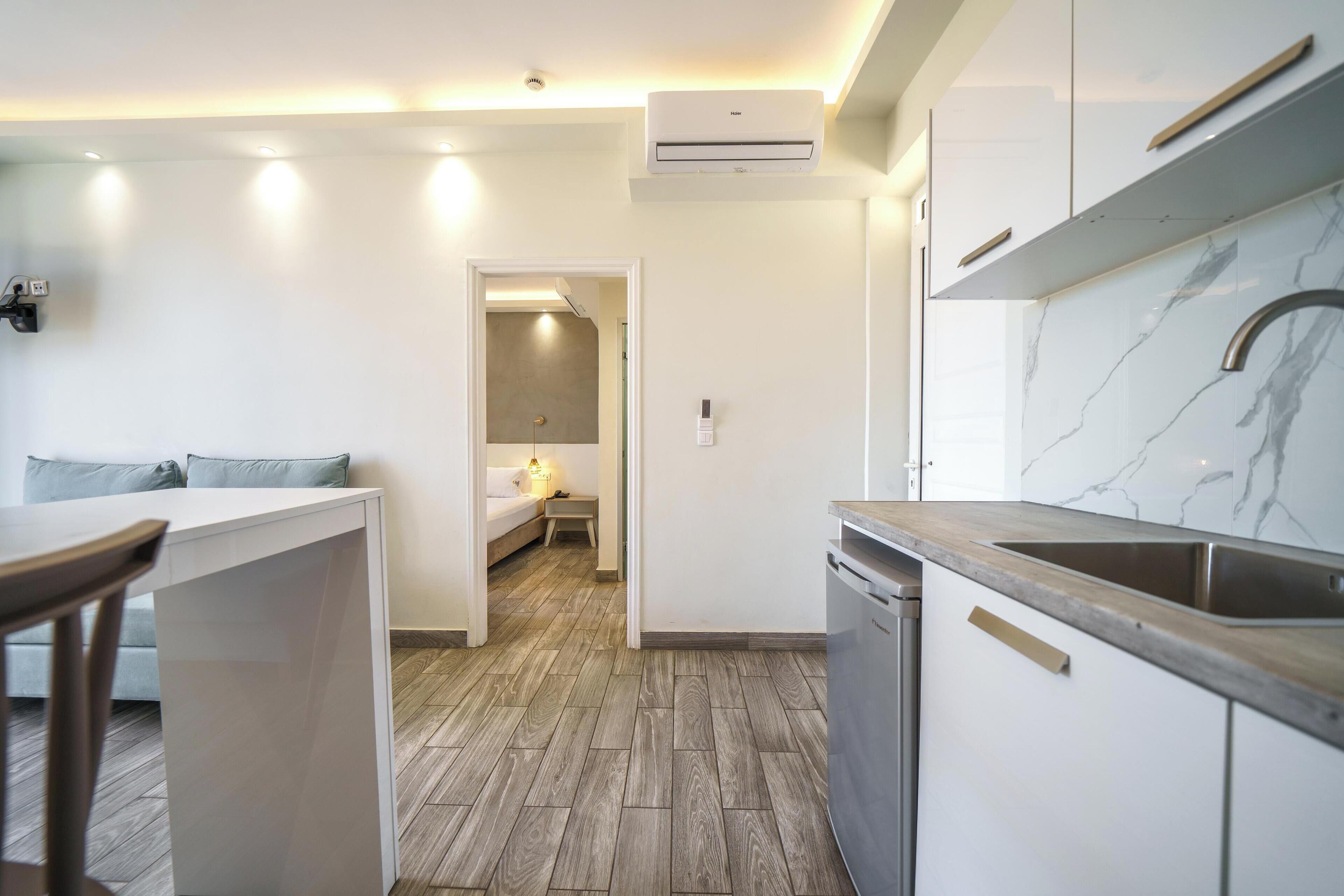 A modern kitchen with white cabinets, a marble backsplash, and a built-in dishwasher.