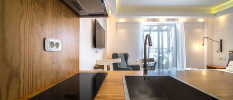 A modern kitchen with a built-in stove, a sink, and a wooden countertop.