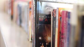 A row of books on a shelf in a library or bookstore.