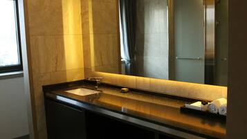 A modern bathroom with a large mirror, a sink, and a shower.