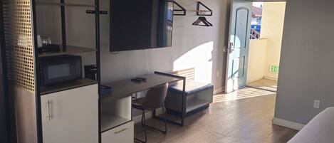 A modern hotel room with a desk, chair, and a bed.