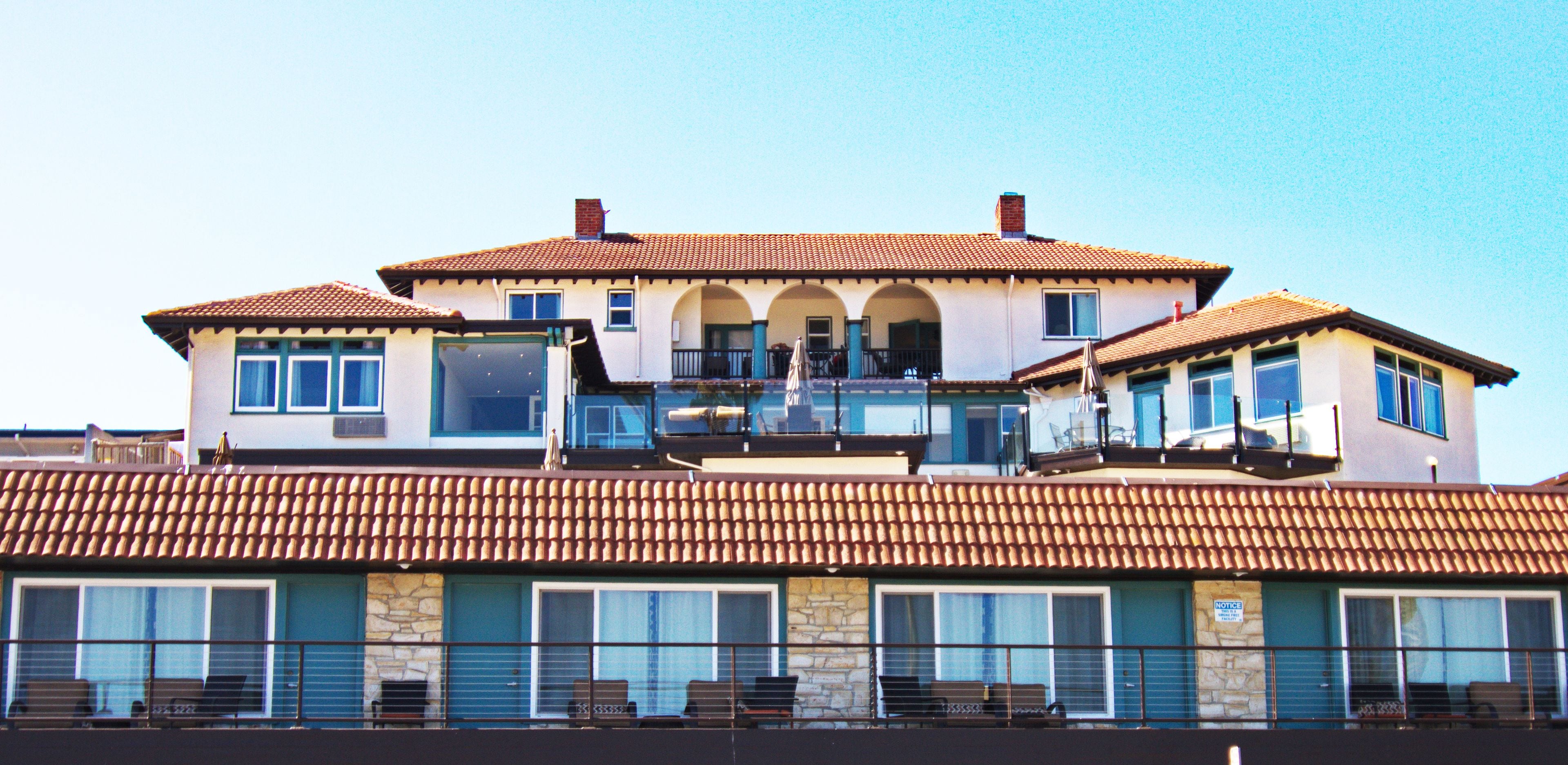 A multi-story building with a tiled roof, large windows, and balconies.