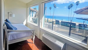 Una habitación con cama, ventana y vista al mar.