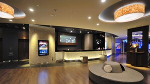 A modern lobby with a reception desk, a large flat-screen TV, and a comfortable seating area. - Dormy Inn Premium Shibuya Jingumae Hot Spring (Tokyo)