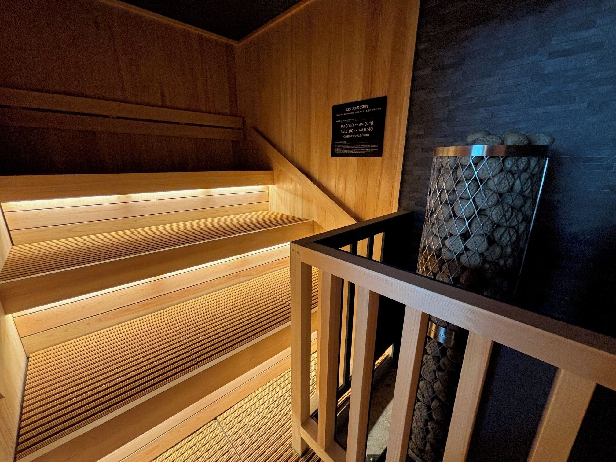 Een sauna met houten banken en een stenen muur.