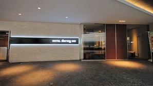 A modern hotel entrance with a prominent sign reading "HOTEL DARMY INN". - Dormy Inn Premium Shibuya Jingumae Hot Spring (Tokyo)