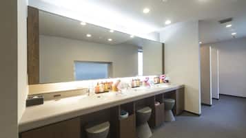 A modern bathroom with a long vanity, multiple sinks, and a large mirror.