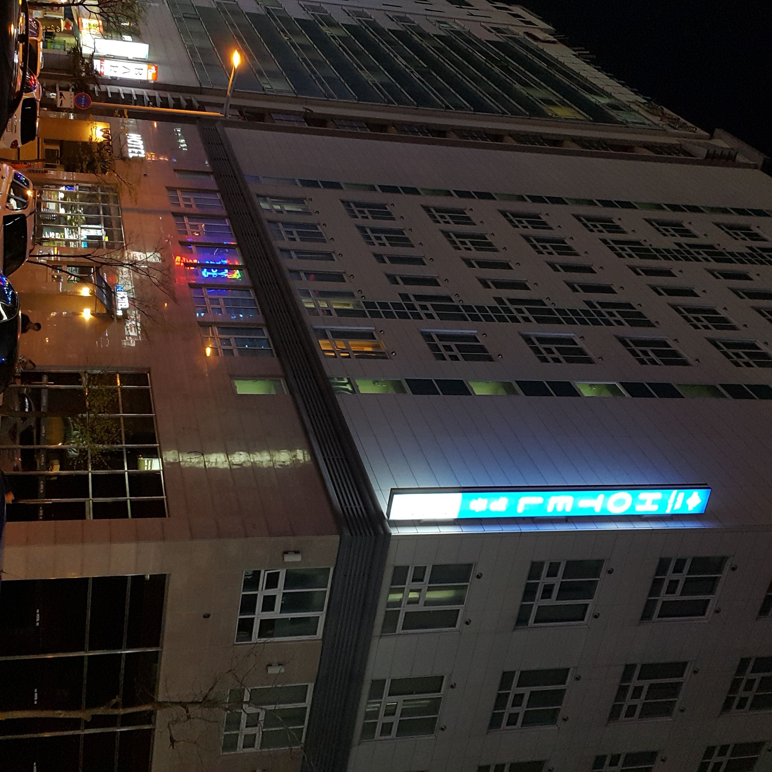 A hotel with a modern facade, multiple windows, and a prominent sign indicating amenities.