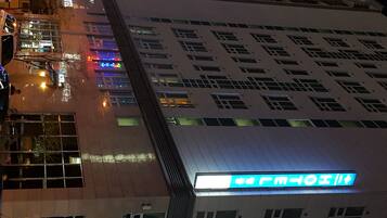 A hotel with a modern facade, multiple windows, and a prominent sign indicating amenities.