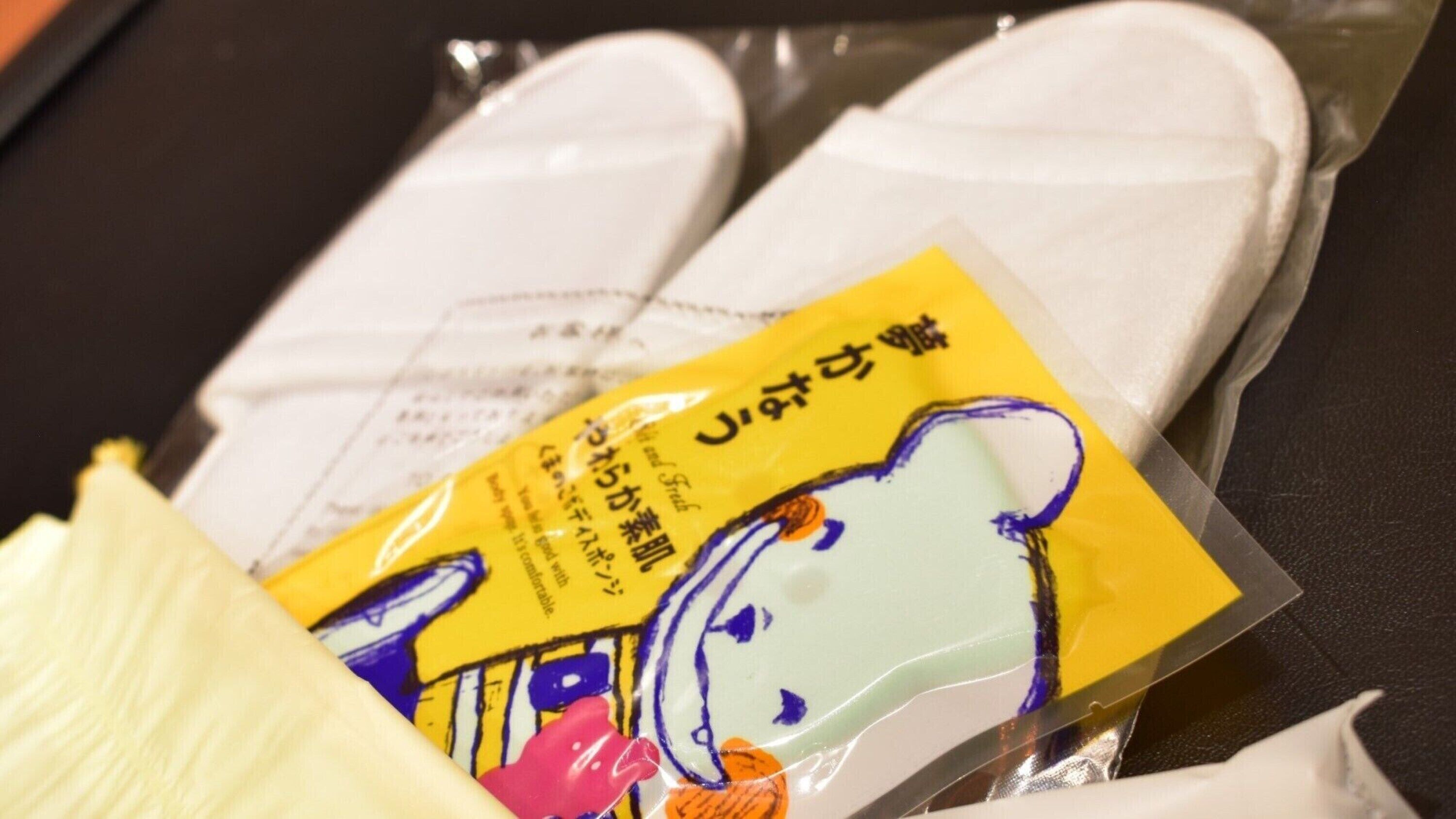 A package of white slippers with a yellow label and a cartoon character.
