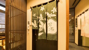 A hotel room entrance with a sliding door, a wooden partition, and a telephone. - Dormy Inn Premium Wakayama Natural Hot Spring (Wakayama)