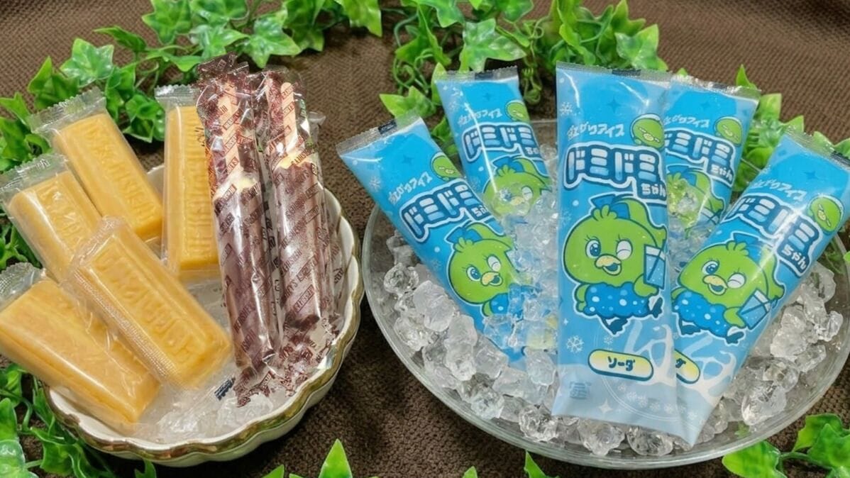 Un plateau contenant de la glace et des en-cas emballés, notamment des produits de couleur jaune et verte.