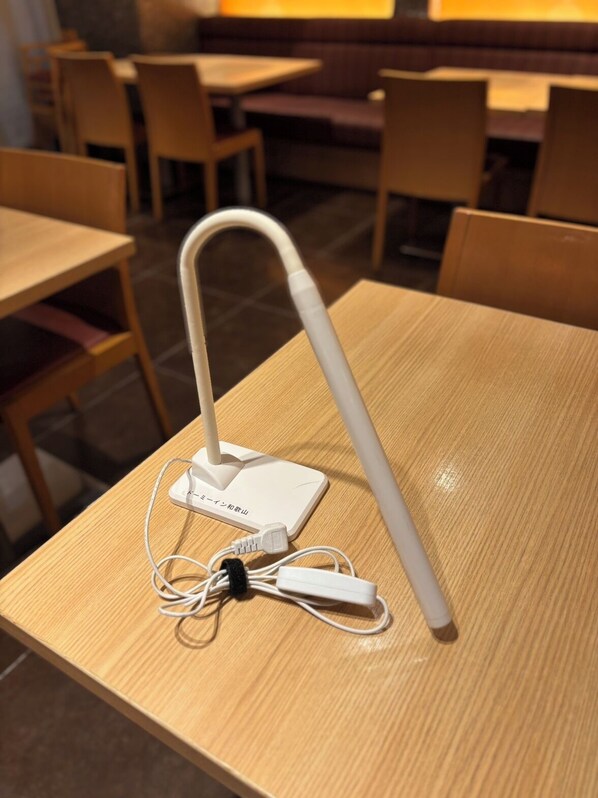 A white portable Wi-Fi hotspot on a wooden table in a restaurant.