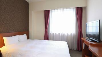 A hotel room with a large bed, a television on a wooden stand, and a window with curtains.
