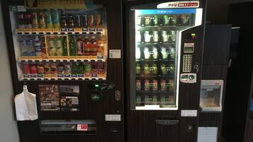 A vending machine with a variety of drinks and snacks, including a Coca-Cola bottle.