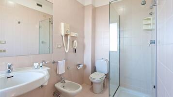 Ein modernes Badezimmer mit Waschbecken, Bidet, Toilette und einer Duschkabine.