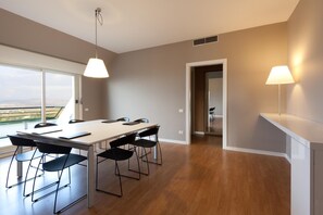 Un comedor moderno con una mesa grande, sillas negras e iluminación colgante.