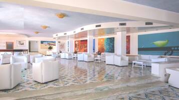 A spacious lobby with white sofas arranged in a U-shape, a patterned floor, and a ceiling with recessed lighting.