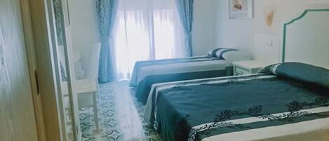 Una habitación de hotel con dos camas, un escritorio y una silla.